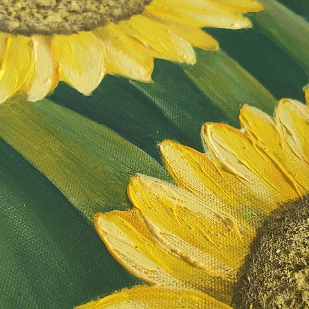 Macro photograph of acrylic painting texture showing vibrant yellow sunflower petals against a deep green background. The brushstrokes are clearly visible, creating rich texture and dimension in the petals.